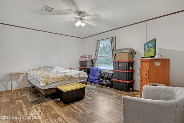 a bedroom with a bed and wooden floor
