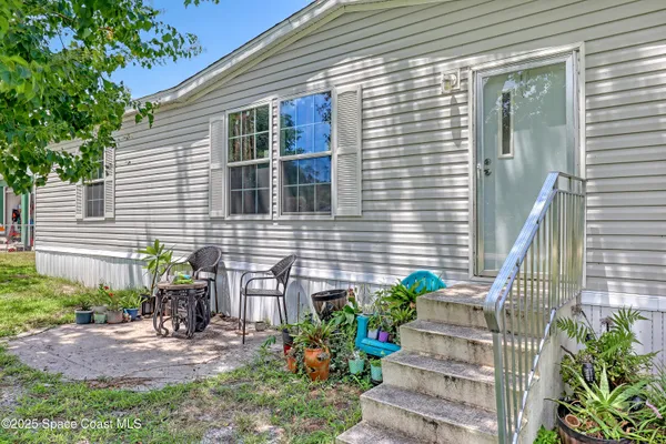 a view of a house with chairs and table in a patio
