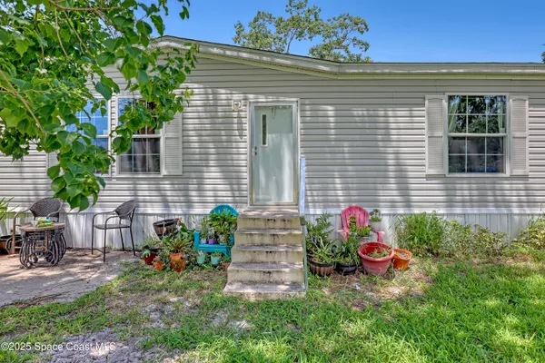 a view of a house with a chairs in a yard