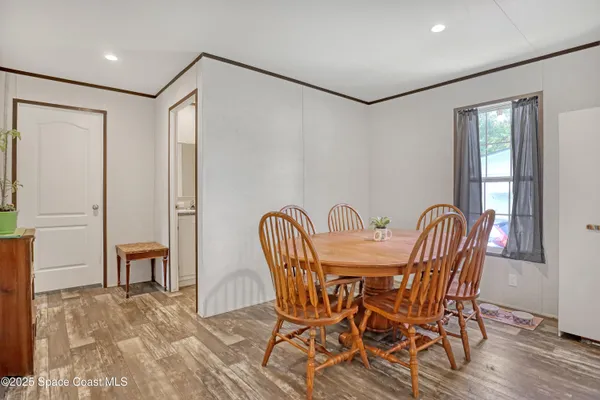 a view of a a dining room with furniture window and wooden floor