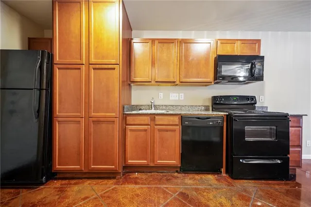 a kitchen with stainless steel appliances granite countertop a refrigerator and a stove