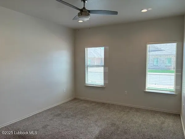 an empty room with a window and ceiling fan