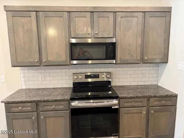 a kitchen with granite countertop white cabinets and stainless steel appliances
