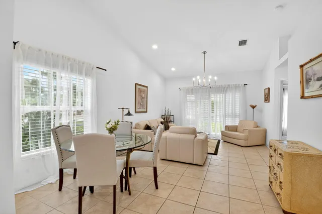 a view of a dining room with furniture a chandelier and wooden floor