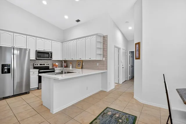 a kitchen with white cabinets and stainless steel appliances