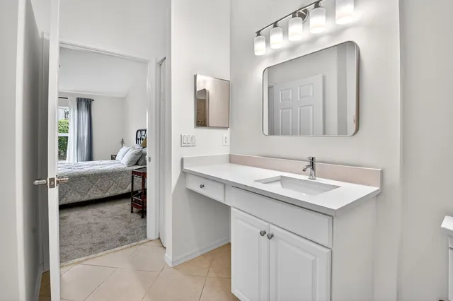 a backyard of a house with table and chairs plants and large tree