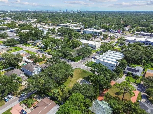 an aerial view of residential houses with outdoor space and trees