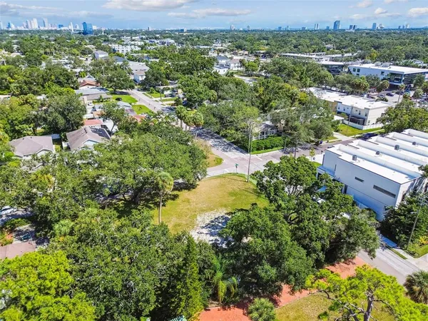 an aerial view of residential houses with outdoor space and trees