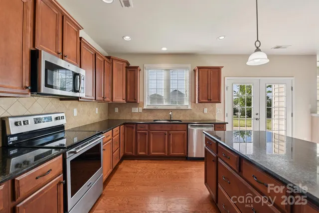 a kitchen with stainless steel appliances granite countertop a stove and a sink