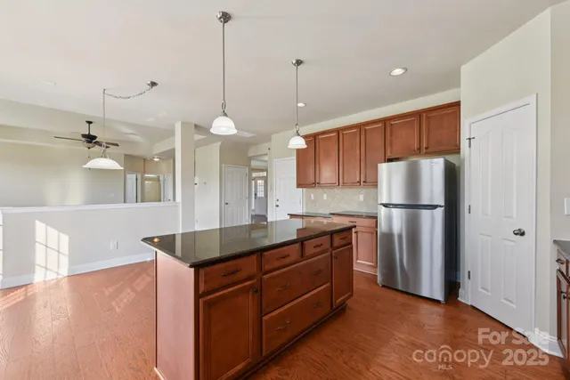 a kitchen with stainless steel appliances granite countertop a refrigerator a sink and a stove