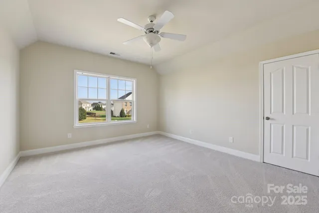 an empty room with windows and ceiling fan