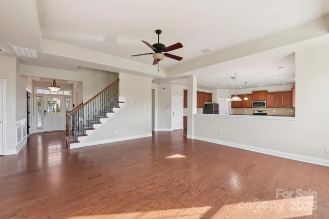 a view of a hallway with wooden floor and a chandelier