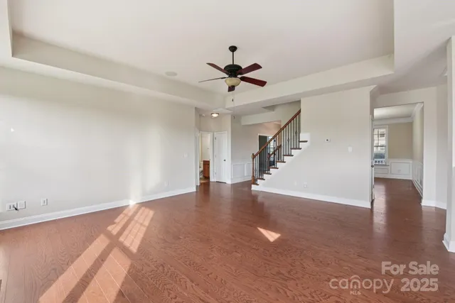 a view of a livingroom with wooden floor and a ceiling fan