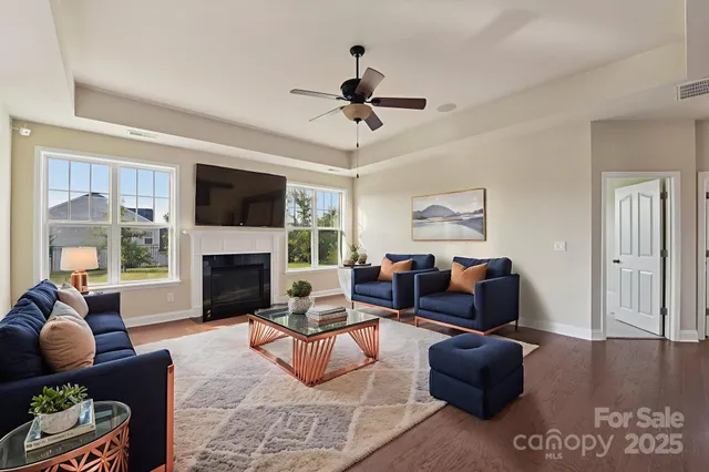 a living room with furniture a fireplace and a flat screen tv