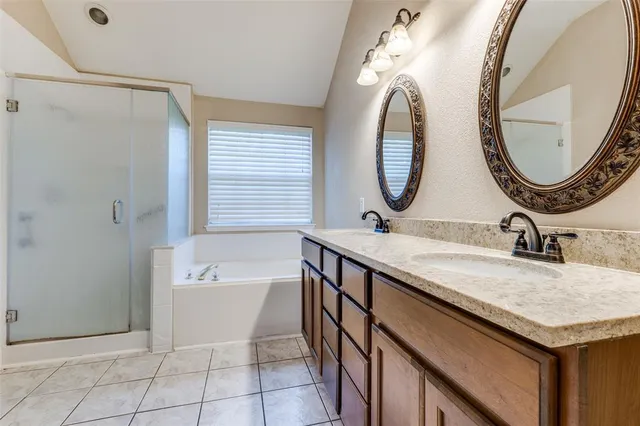 a bathroom with a granite countertop sink mirror and a bathtub