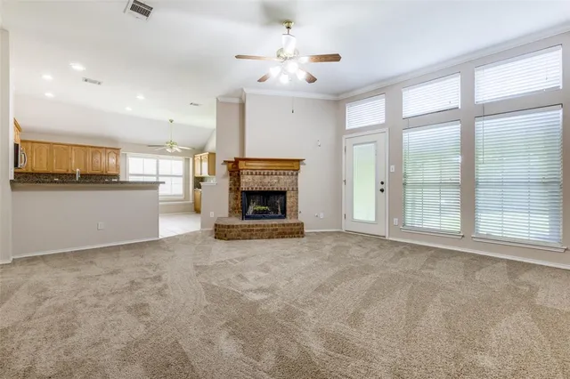 a view of an empty room with a fireplace and a window