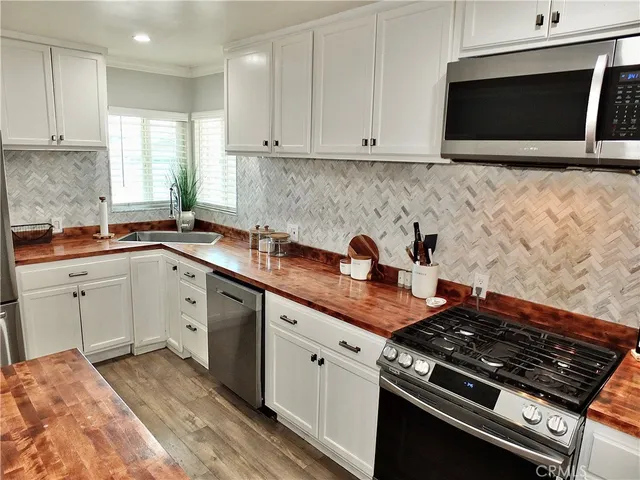 a kitchen with stainless steel appliances granite countertop a sink stove and microwave