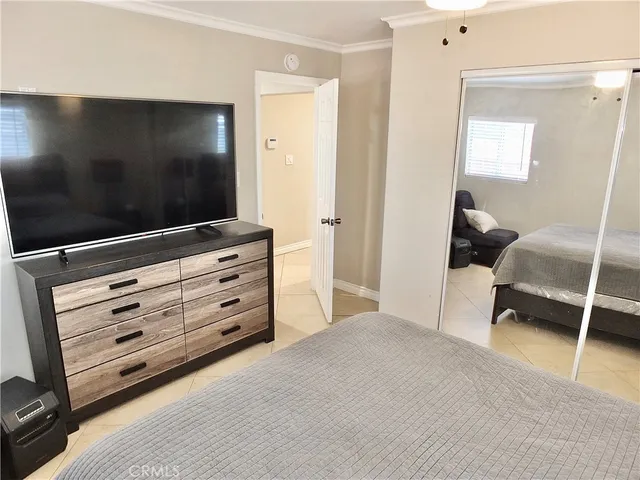 a white bed sitting in a bedroom next to a window