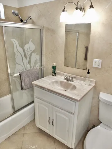 a bathroom with a granite countertop sink a toilet and a mirror