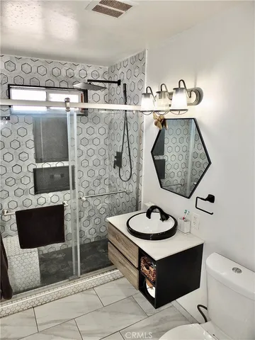 a bathroom with a sink a toilet and mirror