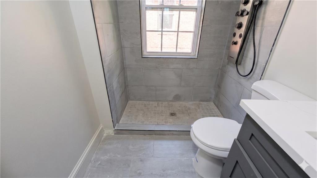 665 Lexington Avenue Southwest Atlanta, GA 30310 - Photo 21 of 33 a bathroom with a granite countertop toilet a sink and a shower