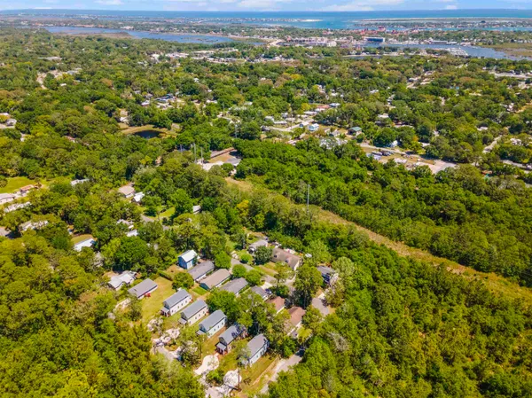 an aerial view of residential houses with outdoor space and trees