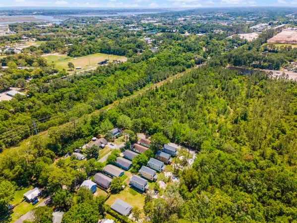 an aerial view of residential houses with outdoor space and trees