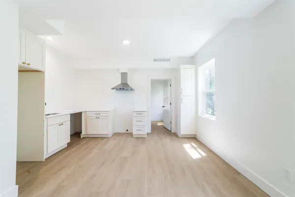 a view of empty room with wooden floor