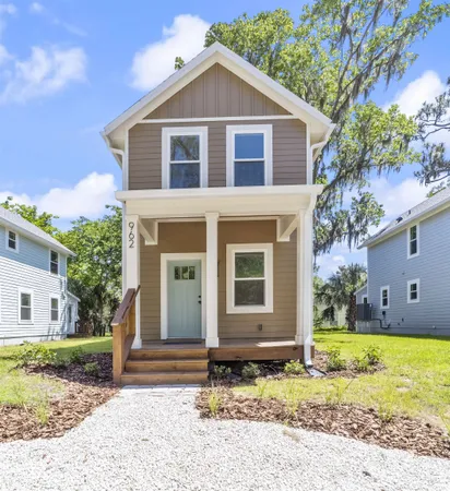 a front view of a house with a yard and trees