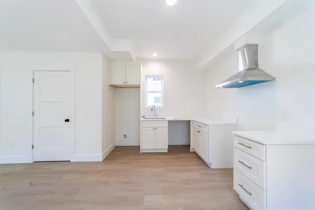 a view of a kitchen with white cabinets