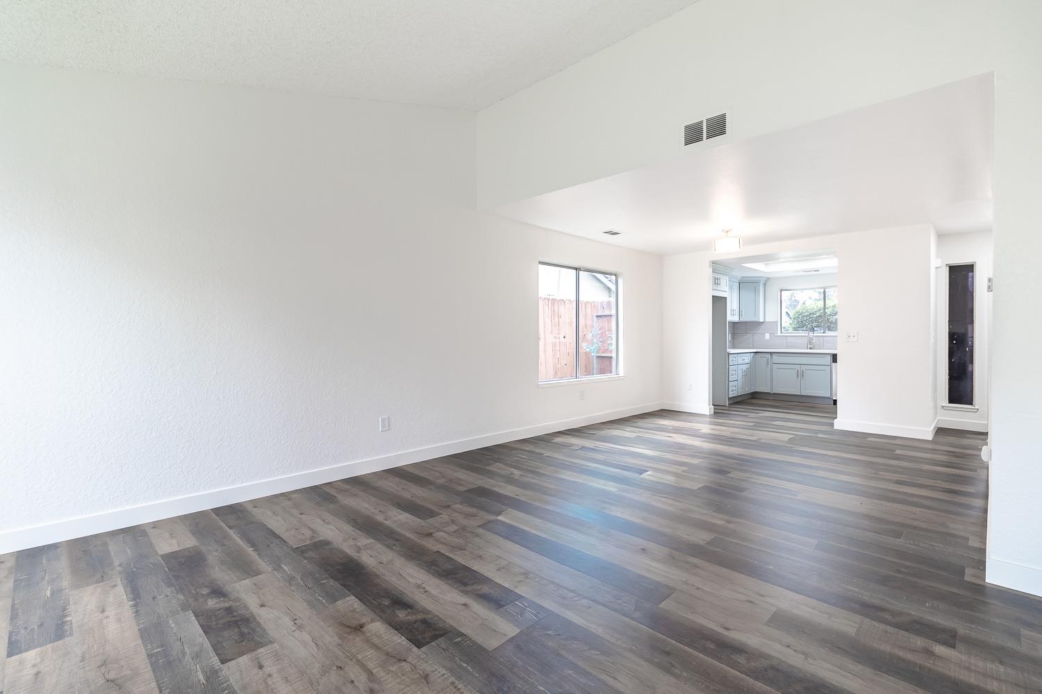 1128 Diablo Avenue Modesto, CA 95358 - Photo 9 of 23 an empty room with wooden floor and windows