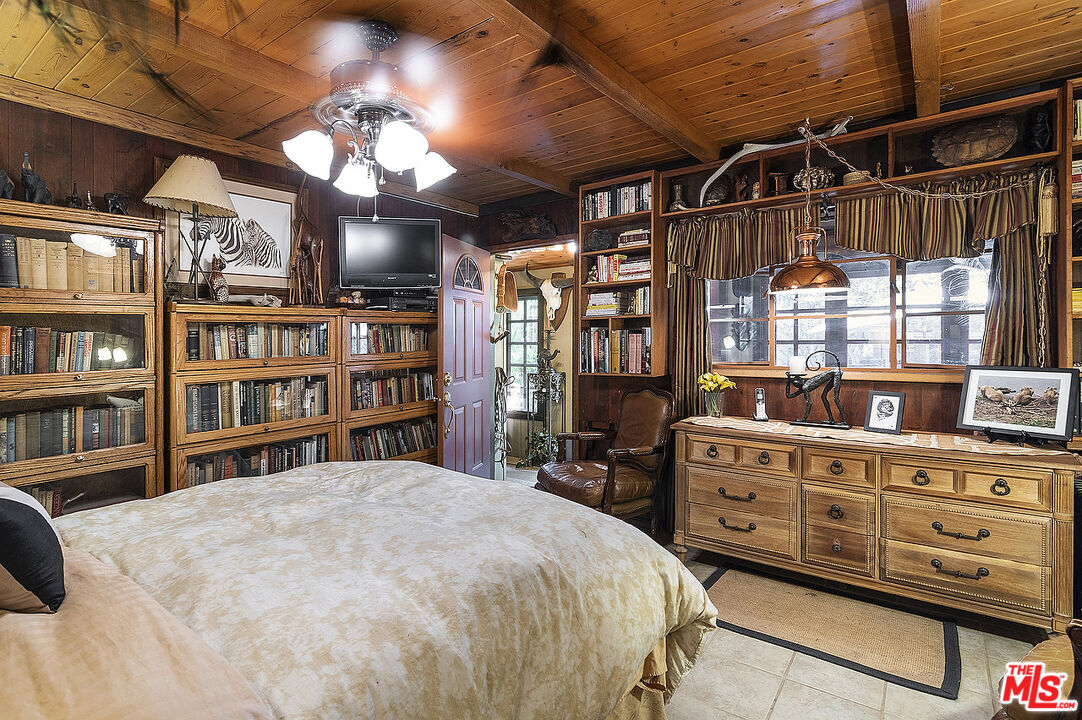14831 Little Tujunga Canyon Road Sylmar, CA 91342 - Photo 32 of 49 a spacious bedroom with a bed a dresser and a book shelf