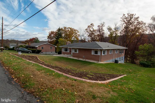 a view of house with garden space and sitting area