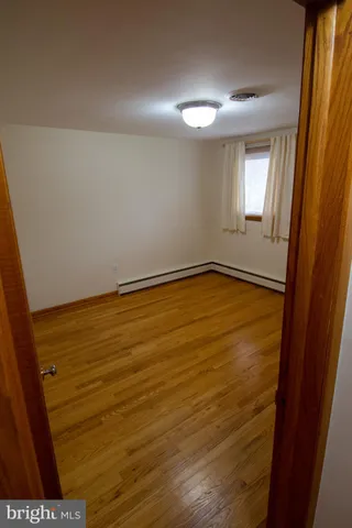 a view of an empty room with wooden floor