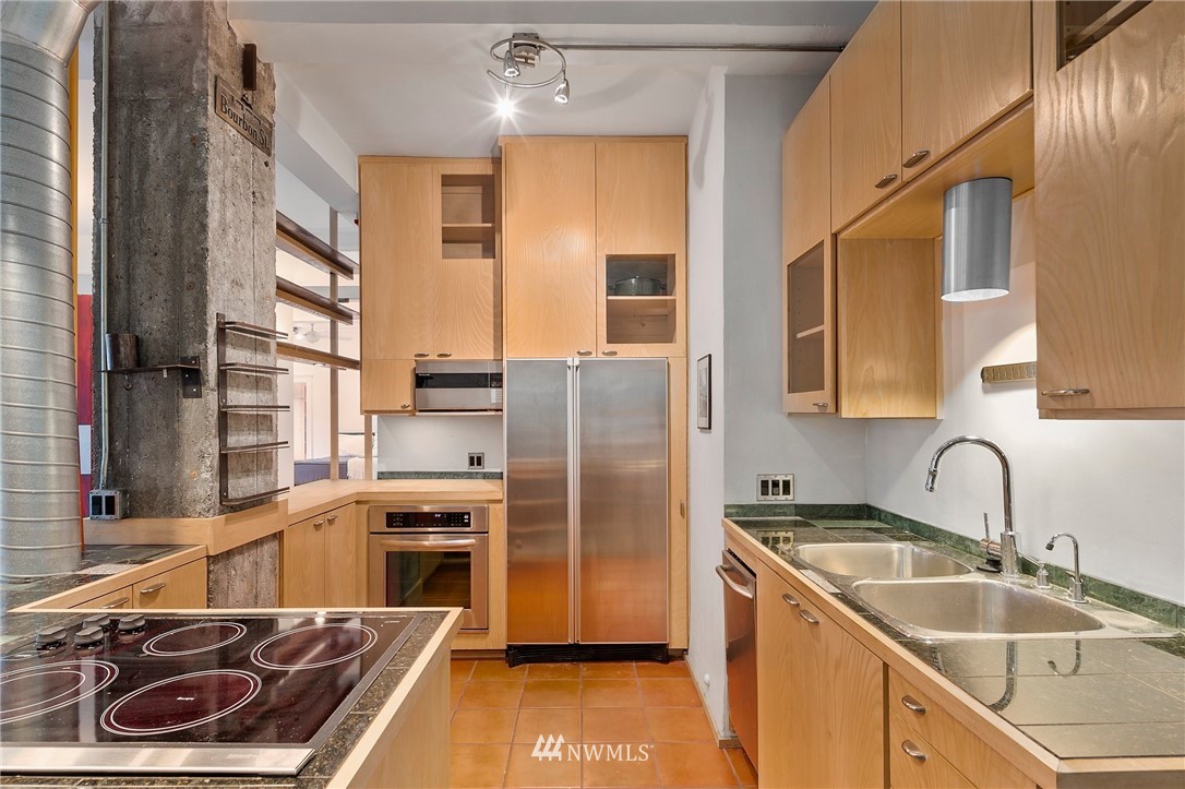 1519 3rd Avenue, Unit 302 Seattle, WA 98101 - Photo 12 of 26 a kitchen with stainless steel appliances granite countertop a sink stove and refrigerator