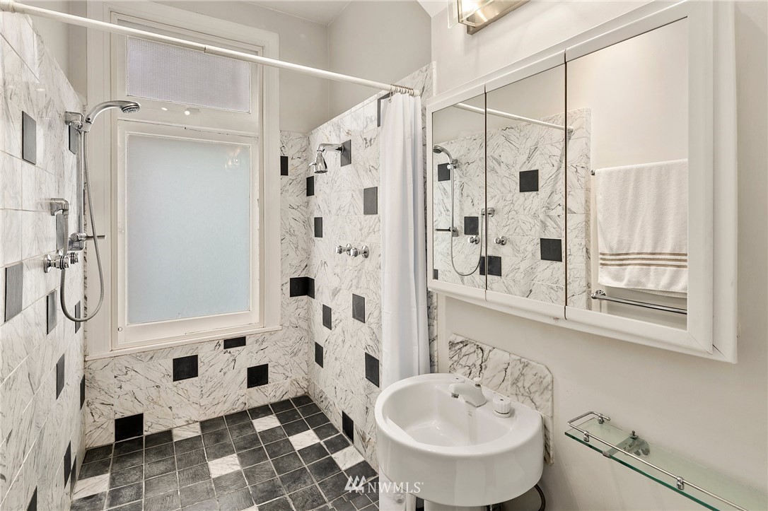 1519 3rd Avenue, Unit 302 Seattle, WA 98101 - Photo 23 of 26 a bathroom with a sink toilet and shower