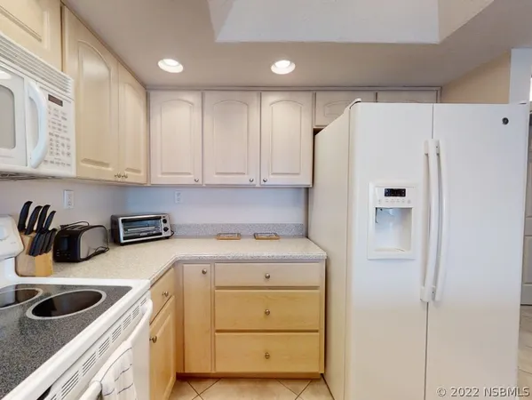 a kitchen with a refrigerator sink and cabinets
