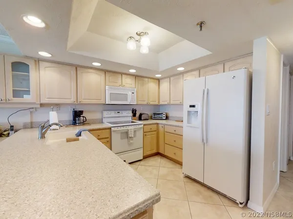 a kitchen with a refrigerator a sink and cabinets