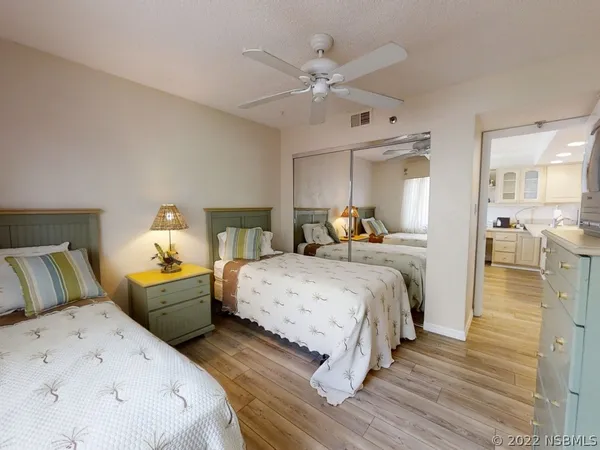 a bedroom with two beds and a chandelier