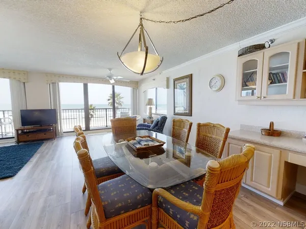 a view of a dining room with furniture a chandelier and wooden floor
