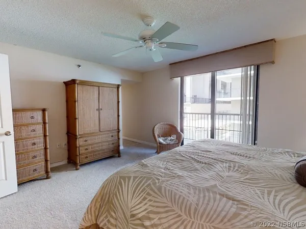 a bedroom with a bed a dresser and a large window