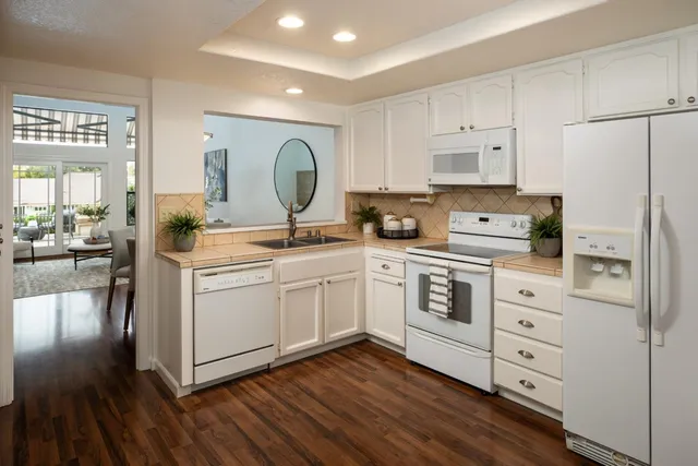 a kitchen with white cabinets and white appliances