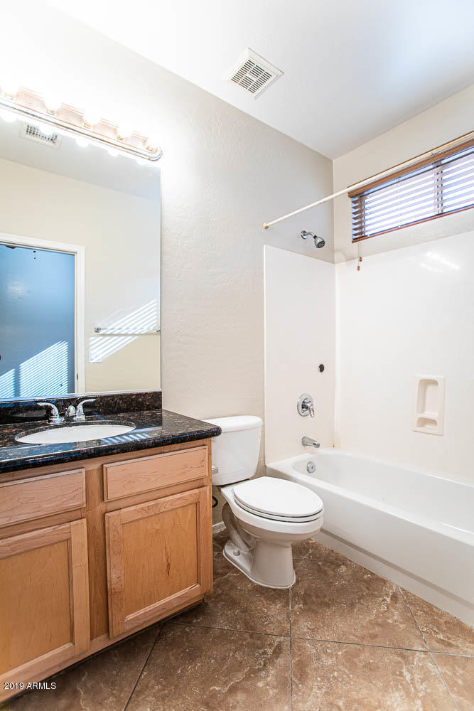 484 East Ranch Road Gilbert, AZ 85296 - Photo 19 of 36 a bathroom with a granite countertop sink a toilet a mirror and bathtub