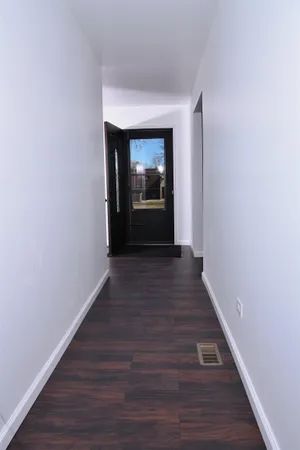 an empty room with a window and wooden floor