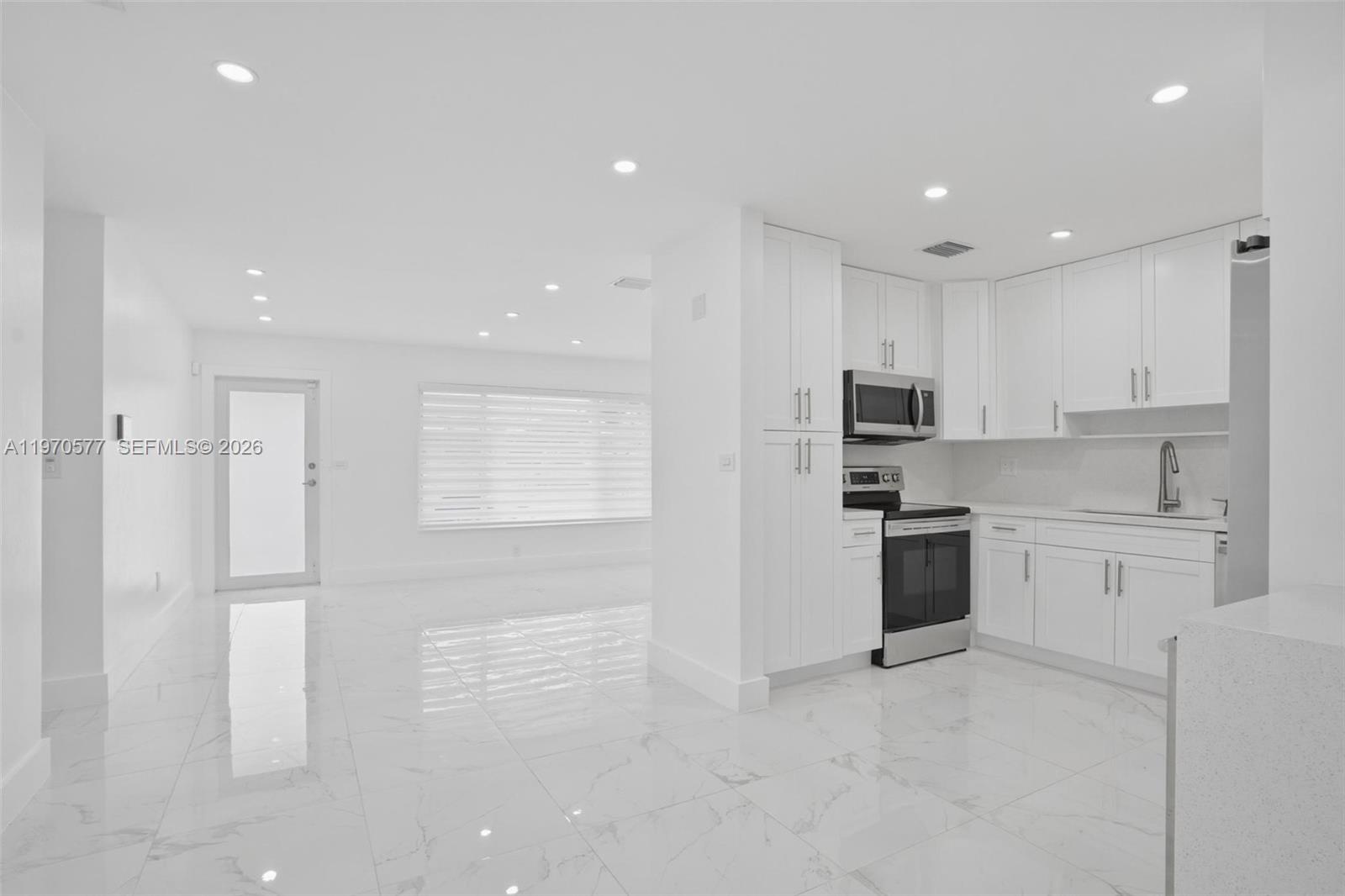 5521 Southwest 104th Avenue Miami, FL 33165 - Photo 6 of 28 a open kitchen with white cabinets and stainless steel appliances