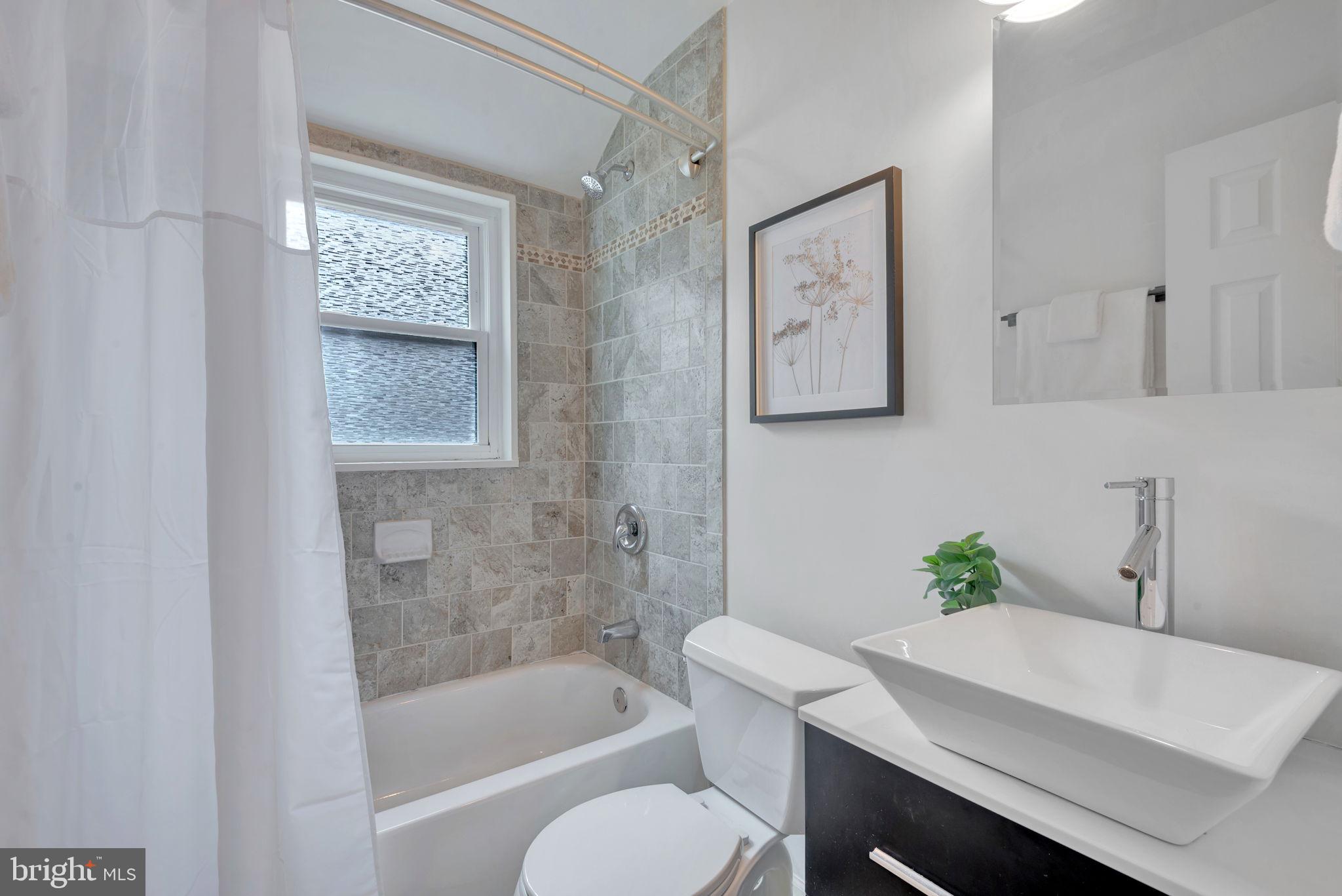 2842 30th Street Northeast Washington, DC 20018 - Photo 12 of 18 a white bath tub sitting next to a white toilet