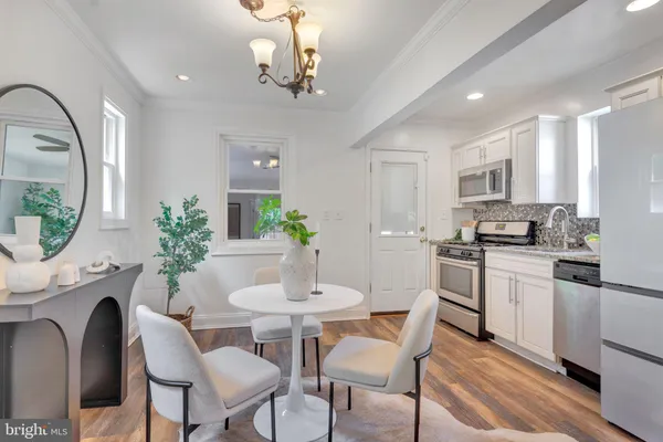 a kitchen with stainless steel appliances granite countertop a dining table chairs and granite counter tops