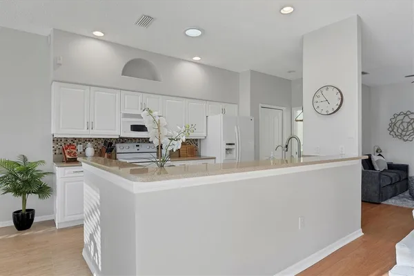 a kitchen with granite countertop a sink and white cabinets