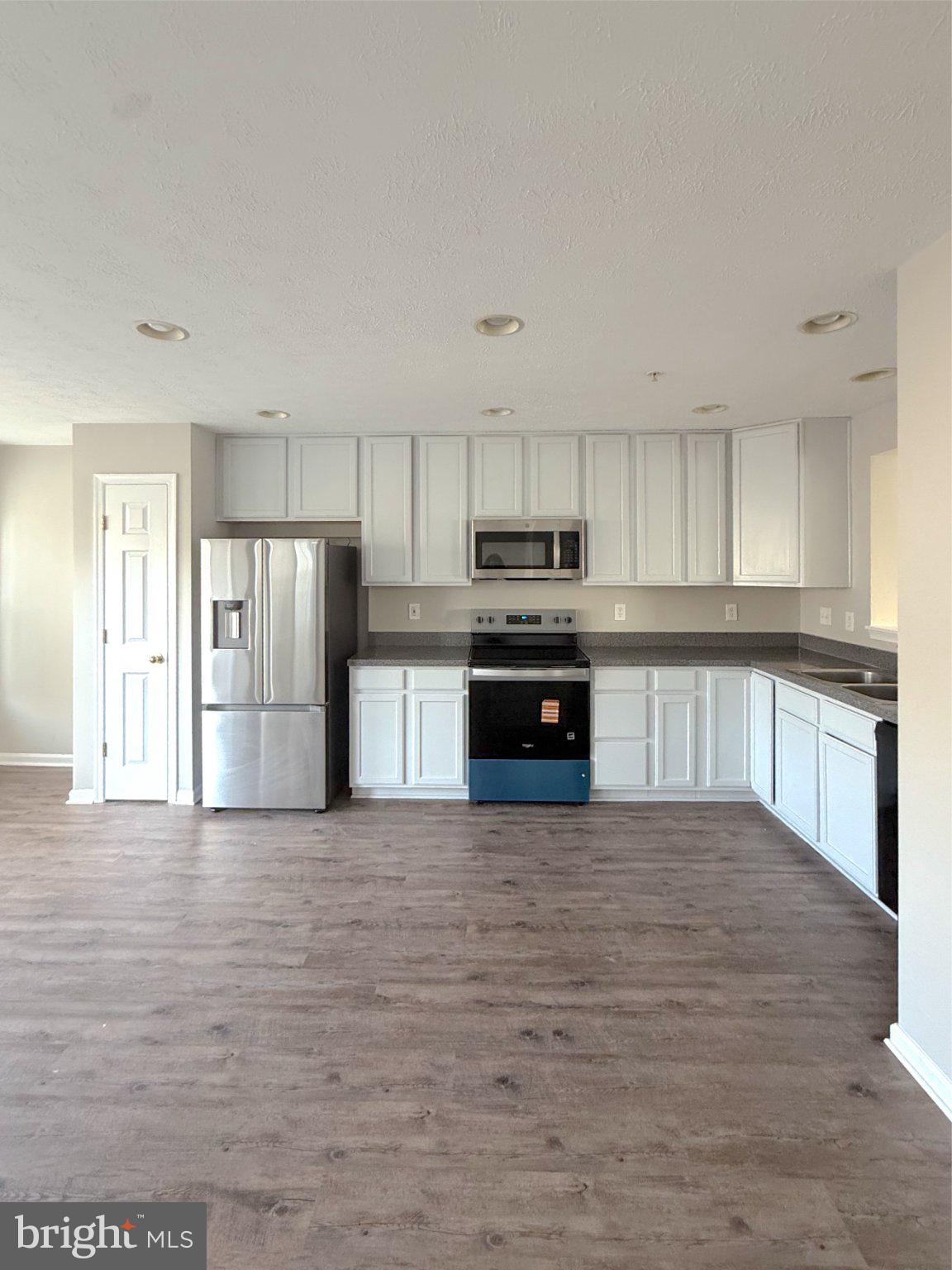 a large kitchen with stainless steel appliances granite countertop a stove and a refrigerator