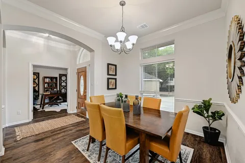 a view of a dining room with furniture wooden floor and chandelier
